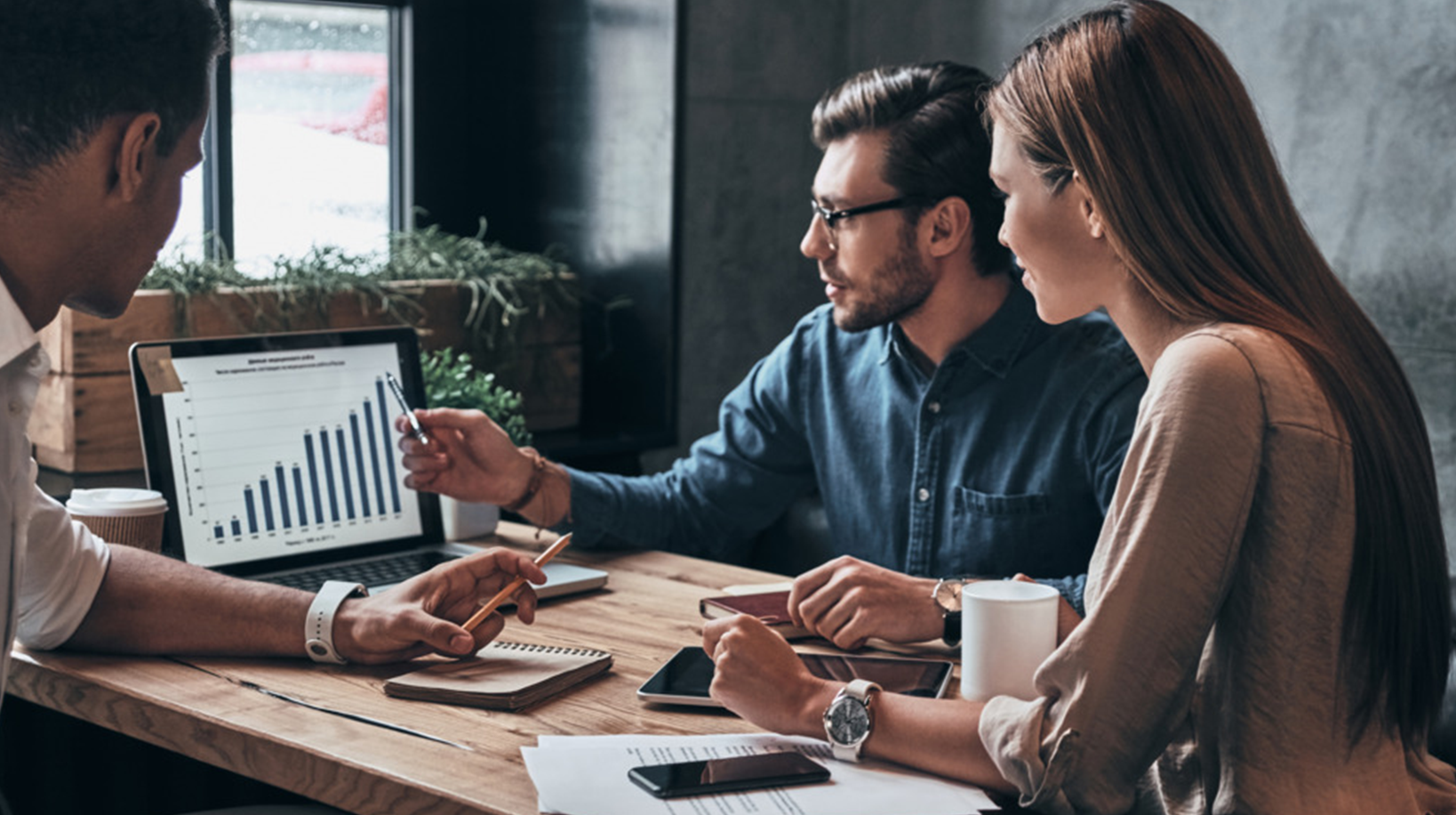 3 personnes discutent autour d'une table
