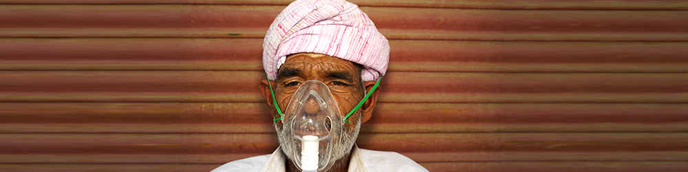 Patient inhaling oxygen wearing mask with liquid Oxygen flow