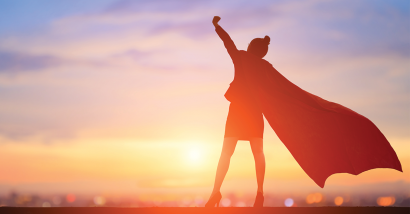 Photo of a woman in a cape, with her hand help up high